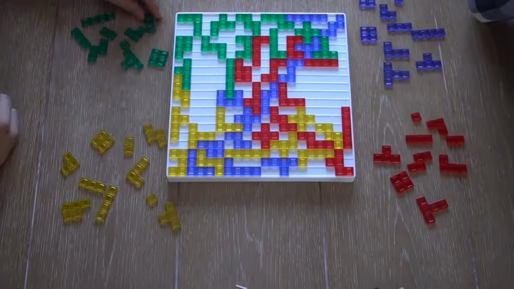 Blokus board game with green, purple, red, and yellow pieces in play