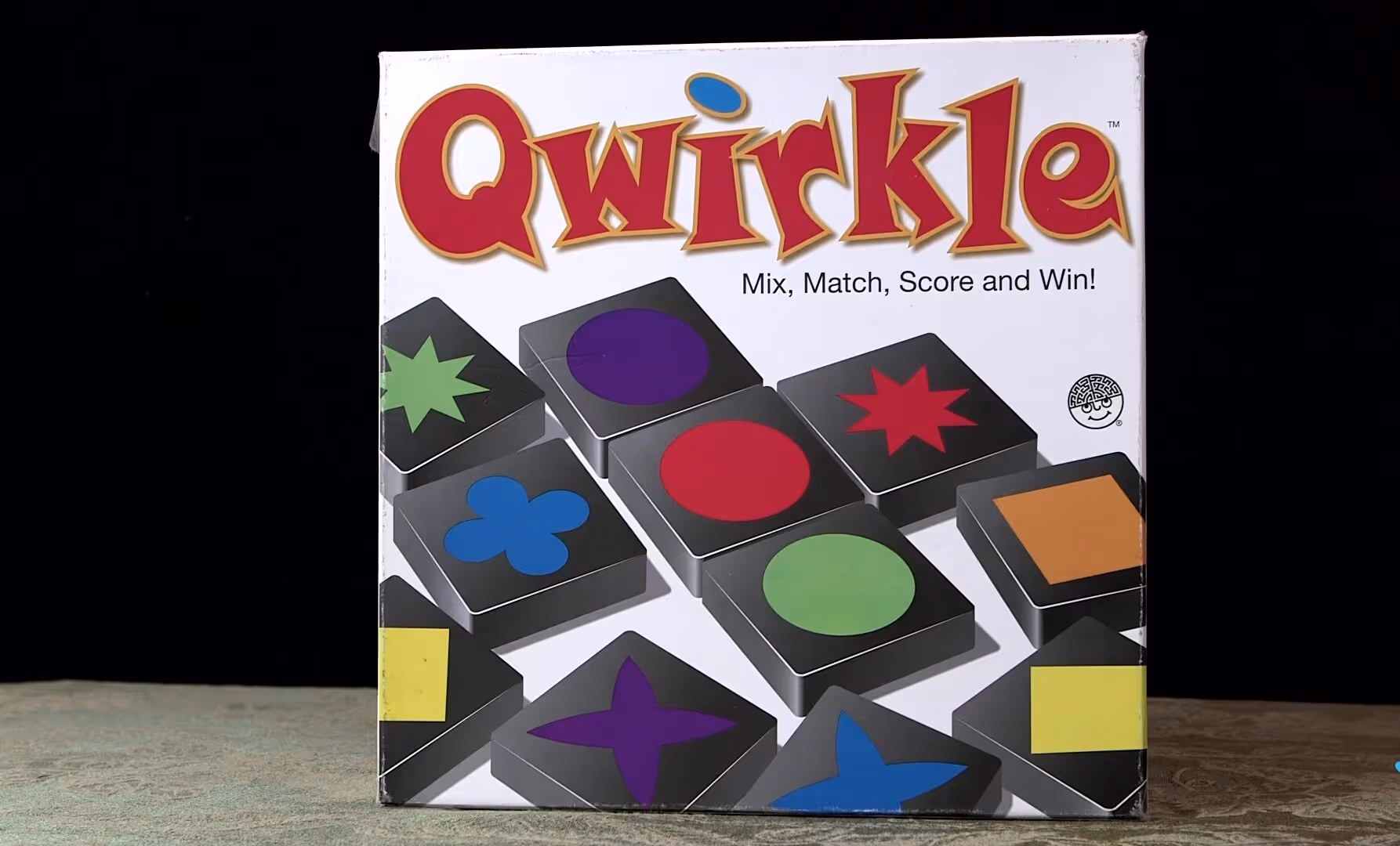 Qwirkle board game box featuring colorful shapes