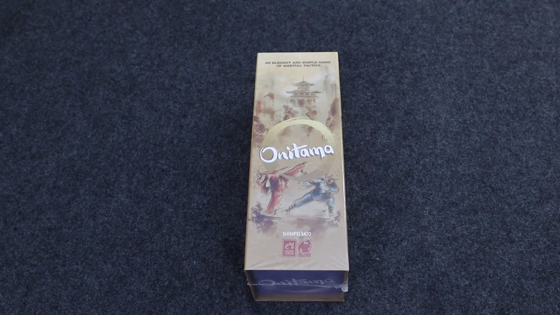 Onitama game box on a dark surface