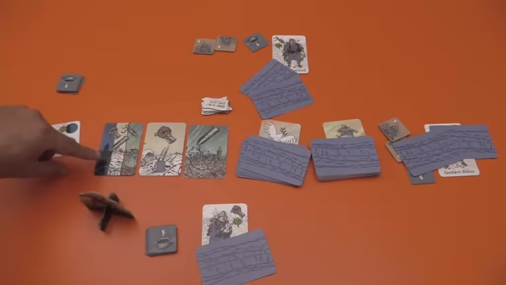 cards on a table for the board game "The Grizzled," showing various game components like threat cards, support tiles, and player cards.
