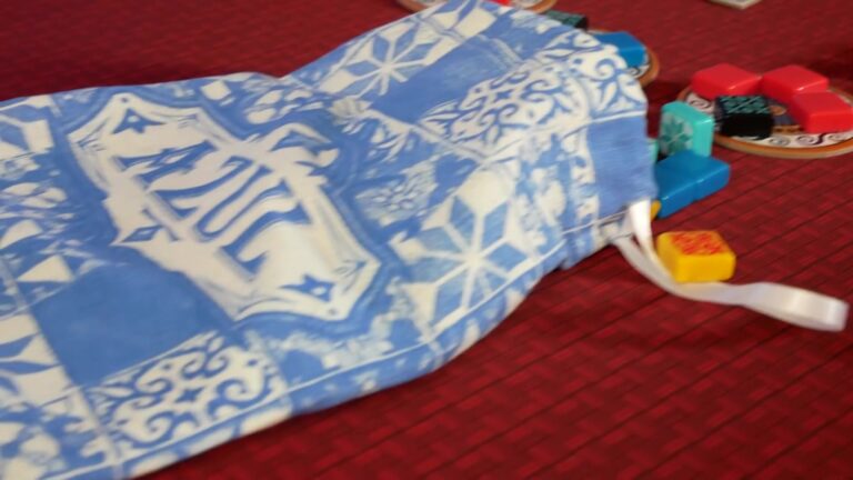 Blue and white patterned fabric bag with small toys.