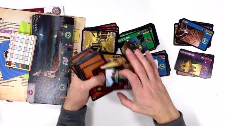 Player organizing cards for 7 Wonders board game with rulebook open.