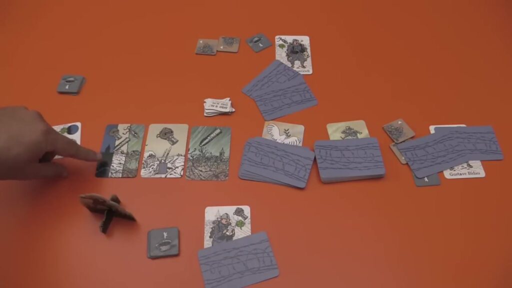 cards on a table for the board game "The Grizzled," showing various game components like threat cards, support tiles, and player cards.